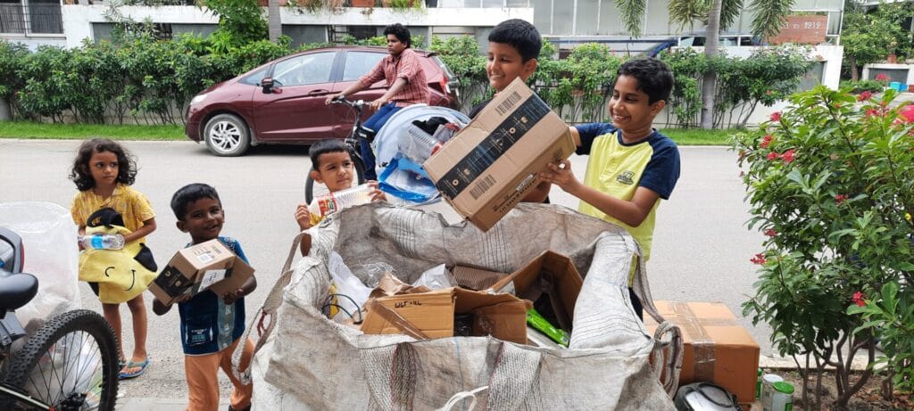 Kids dropping recyclables for collection. 