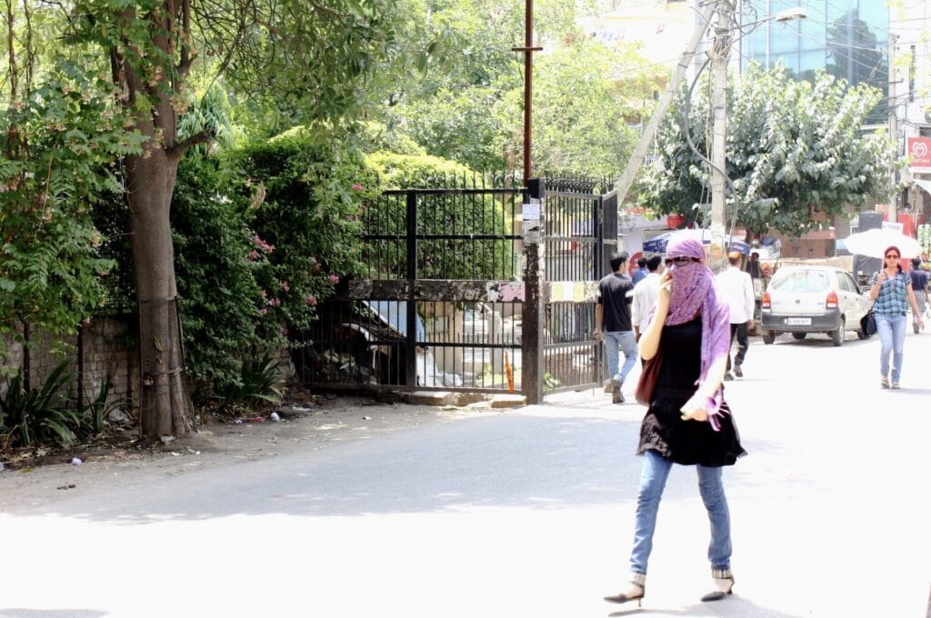 girl covers face to protect from Delhi heat