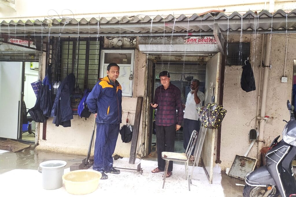 Two men stand in front of a unit at the Kanal Industrial Estate at Daulat Nagar, which is adjoining the Dahisar river.