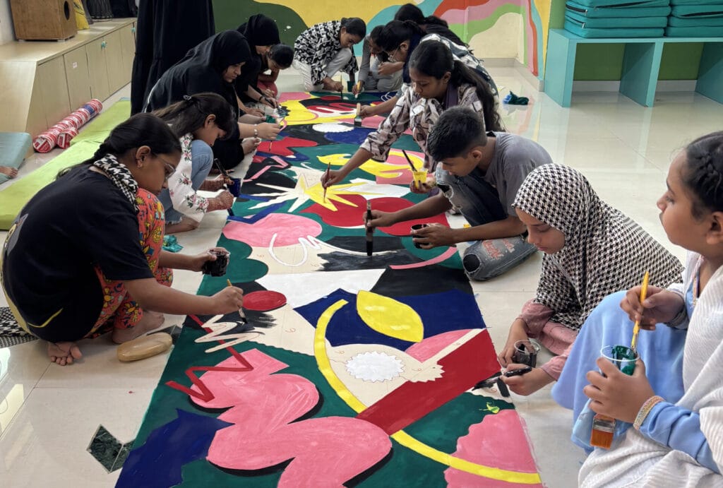 Children creating a long painting